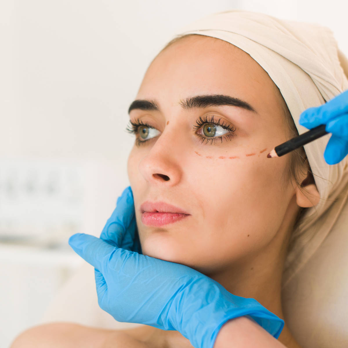 Doctor drawing marks on female face